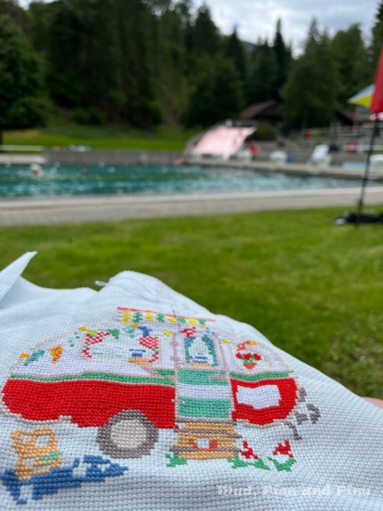 Stitching a picture of a caravan while sitting by the pool